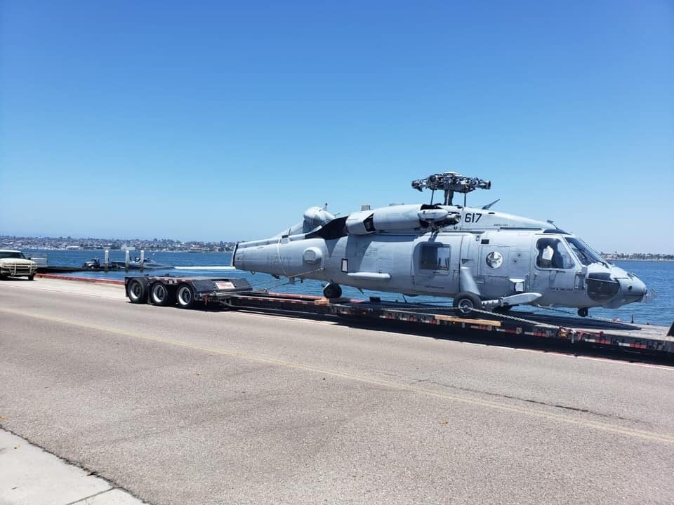 Navy helicopter being moved on a step deck